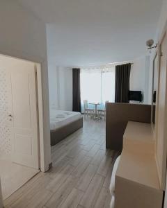 a white room with a bed and a bathroom at Hotel Restaurant Univers Shiroke in Shirokë