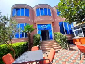 a building with a table and chairs in front of it at Hotel Restaurant Univers Shiroke in Shirokë