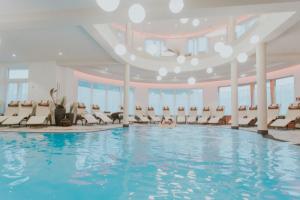 a pool in a hotel with chairs and a person swimming at Wellnesshotel Aumühle in Grein