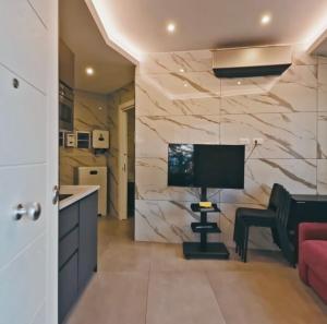 a living room with a television and a desk with a chair at Marco House - Seaview Apartment - Fronte Mare - Case Vacanza Anzio in Anzio