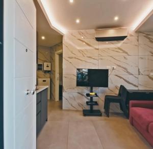 a living room with a couch and a desk with a television at Marco House - Seaview Apartment - Fronte Mare - Case Vacanza Anzio in Anzio