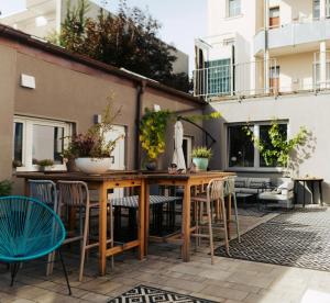 an outdoor patio with a wooden table and chairs at The Kepos Hotel Erlangen in Erlangen