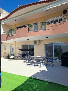 a house with a patio with a table and chairs at KEFI House in Pondolívadhon