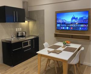 a kitchen with a table and a tv on the wall at Puertovideo in Montevideo