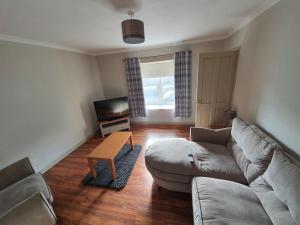 a living room with a couch and a table at Spacious 2 Double Bedroom House Wick Harbour in Wick