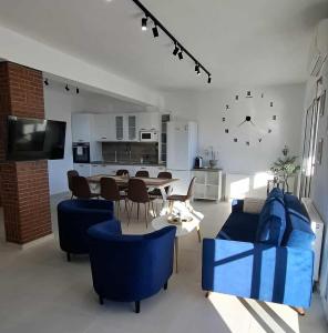 a living room with blue chairs and a table at KEFI House in Pondolívadhon