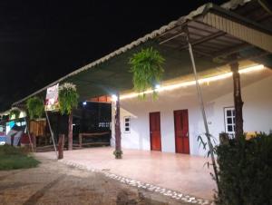 a large white building with a patio at night at Happy house in Ban Khlong Son +2 photos