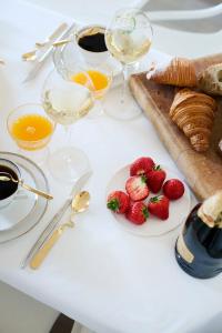 a table topped with plates of strawberries and wine glasses at Maison d'Artiste in Ghent