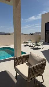 a living room with a couch and a swimming pool at Lamontana villa in Sharīyah