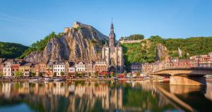 a city with a bridge over a river and a mountain at Hébergement Citabelle in Dinant
