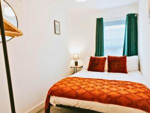 a bedroom with a bed and a window with green curtains at St Helens 3BR Home with Garden, Fast WiFi, Smart TV, Sleeps 6, Contractors & Long Stay Accommodation in Saint Helens