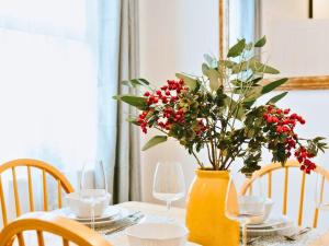 a table with a yellow vase with a plant in it at St Helens 3BR Home with Garden, Fast WiFi, Smart TV, Sleeps 6, Contractors & Long Stay Accommodation in Saint Helens