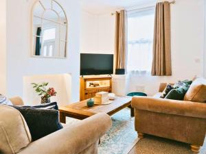 a living room with two couches and a table at St Helens 3BR Home with Garden, Fast WiFi, Smart TV, Sleeps 6, Contractors & Long Stay Accommodation in Saint Helens