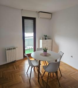 a dining room with a white table and chairs at Area 51 in Banja Luka