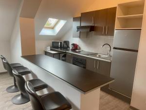 a kitchen with a black counter top and some chairs at Business Apparts Caudry in Caudry