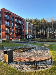 a park with benches in front of a building at Modern apartment with Private parking - 10 min to airport, 15 min Center in Vilnius