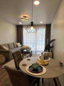 a living room with a table and a couch at Modern apartment with Private parking - 10 min to airport, 15 min Center in Vilnius