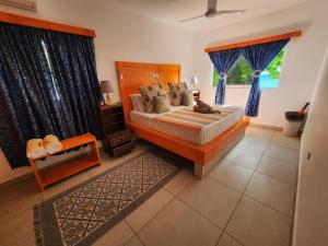 a bedroom with a large bed with blue curtains at Villa Admiral in Praslin