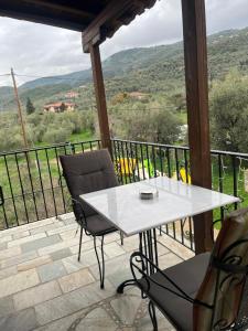 a white table and chairs on a balcony with a view at Studio Sevasti in Kala Nera