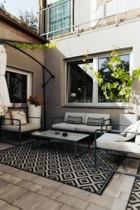 a patio with couches and a coffee table on a rug at The Kepos Hotel Erlangen in Erlangen