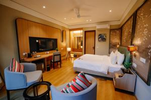 a hotel room with a bed and a desk and chairs at Pride Premier Alwar - Sariska in Alwar