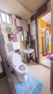 a bathroom with a toilet and a sink at 18 Camella in Baguio