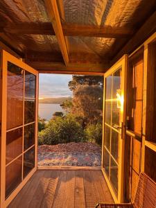 a screened porch with a view of the water at Pine Cottage in Dennes Point