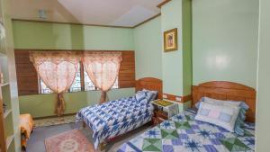 a bedroom with two beds and a window at 18 Camella in Baguio