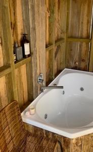 a bath tub with a chair in a bathroom at Pine Cottage in Dennes Point