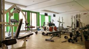 a gym with several exercise equipment and a mirror at AG Hotel & Spa Marrakech in Marrakesh