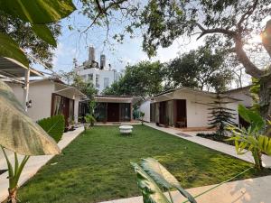a courtyard of a house with a grass yard at Anexx Goa in Vagator