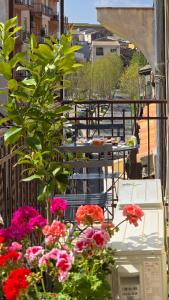 a balcony with pink flowers and tables and chairs at MASA 2Rooms in Piazza Armerina +63 photos