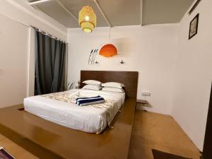 a bedroom with a bed with white sheets at Anexx Goa in Vagator