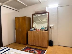 a room with a mirror and a wooden cabinet at Anexx Goa in Vagator