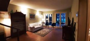a living room with a white couch and a chair at Il Fienile, casa vacanza in campagna con parcheggio privato e giardino privato, a 6 chilometri da Bologna centro e 1 chilometro da Bologna Fiera, Parco commerciale Meraville e Gran Tour Italia in Bologna
