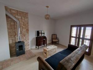a living room with a couch and a wood stove at Cozy rural apartment in Calaceite