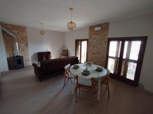 a living room with a table and chairs and a couch at Cozy rural apartment in Calaceite