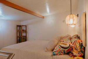 a bedroom with a bed and a chandelier at Cosy Tiny House Centro Vila Real in Vila Real