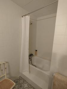 a bathroom with a bath tub with a shower curtain at Cozy rural apartment in Calaceite +21 photos