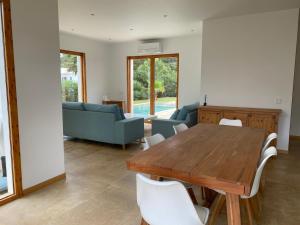 a living room with a wooden table and a couch at Vivez Cala Morell! in Cala Morell