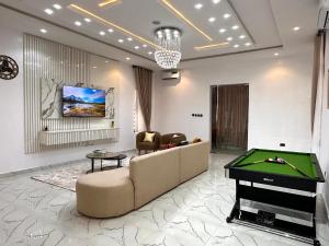 a living room with a couch and a pool table at Tranquil Residences - Orchid, Lekki in Lekki