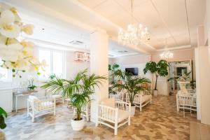 a salon with chairs and plants in a room at Hotel Continental in Pietra Ligure