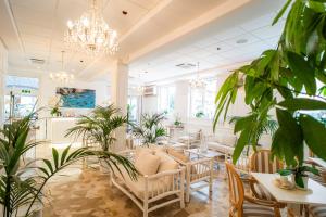 a restaurant with tables and chairs and plants at Hotel Continental in Pietra Ligure +82 photos
