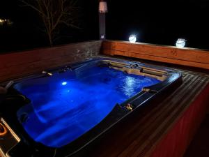 a jacuzzi tub with blue water at night at Bulle Insolite avec Spa Privatif in Durban-Corbières