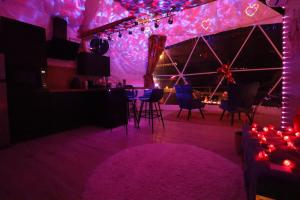 a room with purple lights and a table and chairs at Bulle Insolite avec Spa Privatif in Durban-Corbières +6 photos