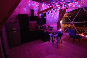 a purple room with a table and chairs in it at Bulle Insolite avec Spa Privatif in Durban-Corbières