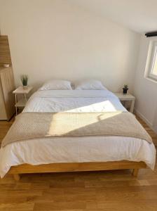 a large bed in a bedroom with two tables at Studio Douillet in Mâcon