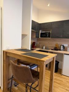 a kitchen with a wooden table and two chairs at Studio Douillet in Mâcon