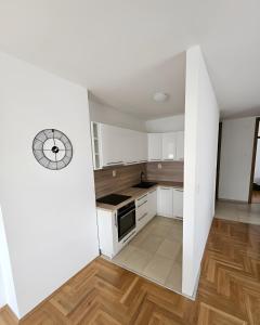 a kitchen with white cabinets and a clock on the wall at Area 51 in Banja Luka +4 photos