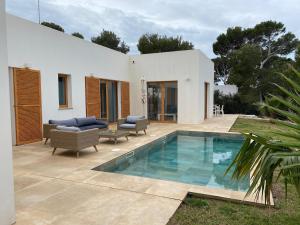 a patio with a swimming pool and a house at Vivez Cala Morell! in Cala Morell